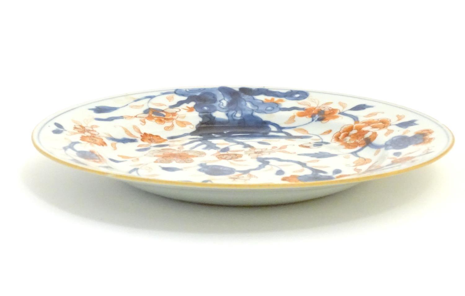 A Japanese plate in the Imari palette with hand painted decoration depicting blossoming flowers. - Image 3 of 4