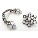 A .835 silver brooch set with moonstone cabochons and marcasite detail. Together with another.