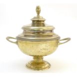 A 19thC brass pedestal pot and cover with twin handles and stylised acorn finial. Approx. 11" high