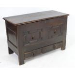 A late 17thC oak mule chest with a moulded lifting lid above a panelled front having geometric