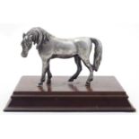 A 20thC cast model of a horse on a rectangular wooden base. Approx. 4" high Please Note - we do