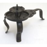 A Japanese bronze candle stand with a raised sconce, on three supports, with scrolling punchwork