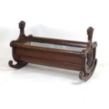 A 19thC oak cradle / ice bucket with carved floral uprights, scrolled mouldings and a carved