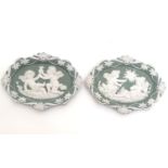 A matched pair of Continental oval wall plaques with jasperware style decoration with putti,