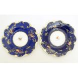 Two 19thC dessert plates with cobalt blue ground scrolling gilt highlights and hand painted bird and
