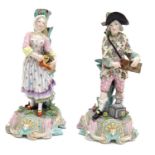 A pair of 19thC Continental figural candlesticks, modelled as a man with a wooden box and lantern,