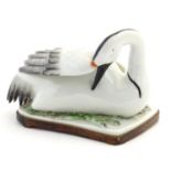 A model of a swan on a fitted wooden base. Approx. 5 1/4" high Please Note - we do not make