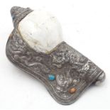 A Tibetan conch shell with embossed metal mounts with floral, foliate, cabochon and mask detail.