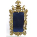 A mid 20thC carved giltwood mirror with a surround adorned with rosettes, birds, swags and