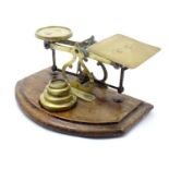 Late 19th / early 20thC postal scales with four weights mounted on a wooden base. Approx. 3 3/4"