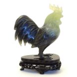 A Chinese jade / hardstone carving modelled as a cockerel / rooster on a carved fitted wooden