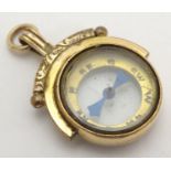 An early 20thC pendant fob set with central compass within a gold plated mounts. Approx. 1" long