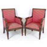 A pair of Regency style armchairs with reeded frames, incised decoration and carved rosettes.