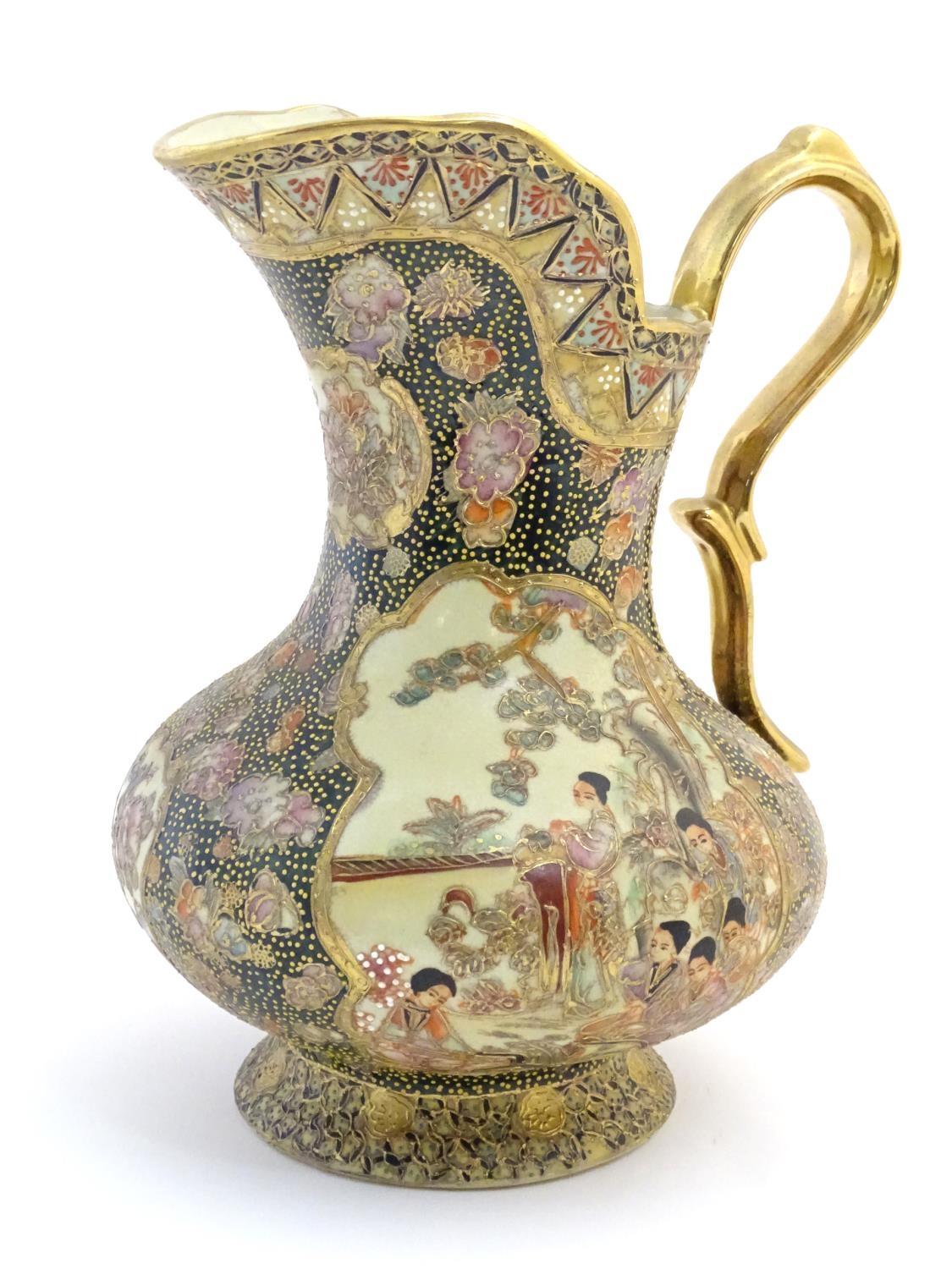 An Oriental jug / ewer with a bulbous body decorated with panels depicting ladies in a garden