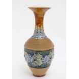 A Doulton Lambeth stoneware vase with a flared rim, ribbed body and banded section with scrolling