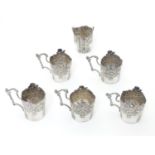 6 Continental silver tot / shot glass holders with embossed decoration and handles . Approx 1 3/4"