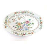 A Chinese famille rose oval dish with hand painted floral and foliate detail, with peonies and