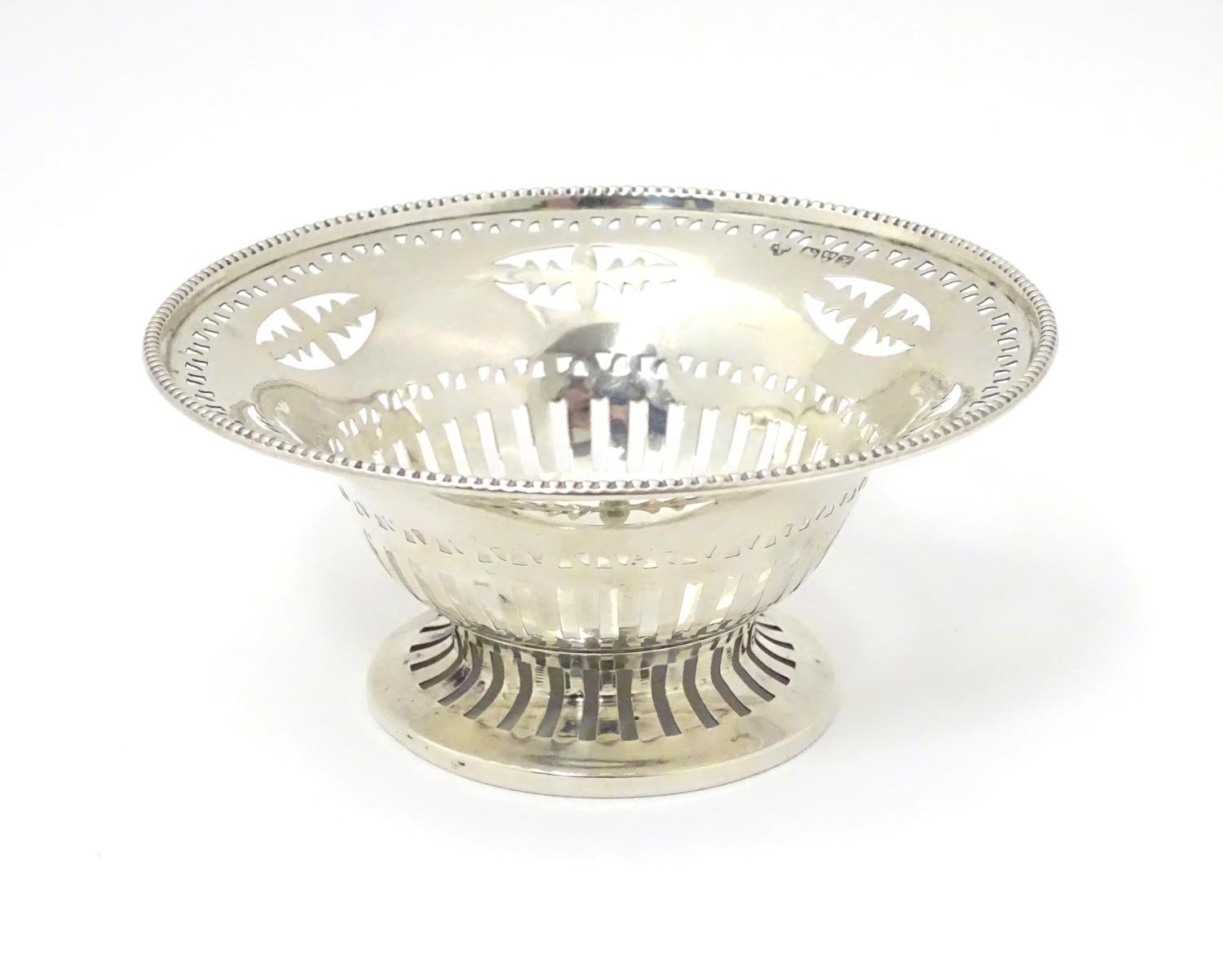 A silver bonbon dish with beaded edge and pierced decoration raised on circular foot. Hallmarked