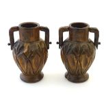 A pair of late 19th / early 20thC treen carved and turned vases with twin handles, dimple decoration