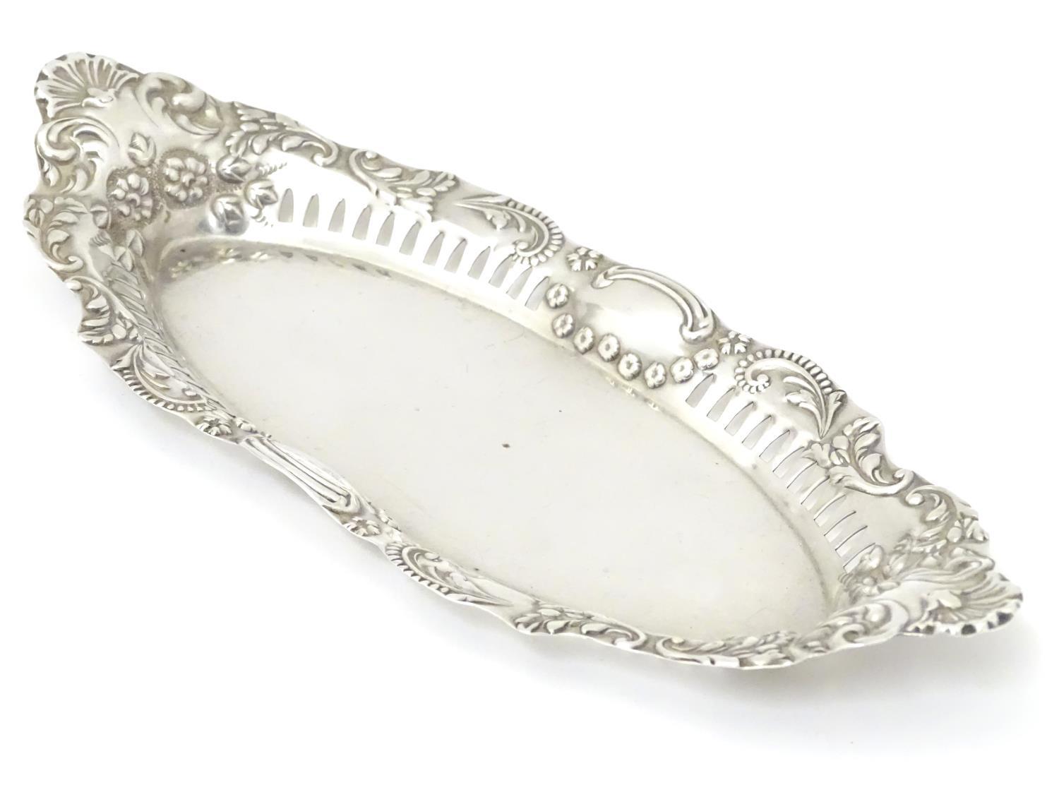 A silver dish of oval form with pierced and embossed decoration , hallmarked Birmingham 1899 maker