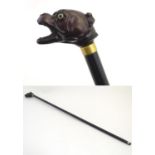 A 20thC ebonised walking cane, the handle modelled as the head of a dog. Approx. 35 1/2" Please Note