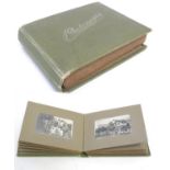 An early 20thC photograph album with sepia and monochrome photos to include group shots in the