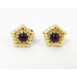 Gold stud earrings set with garnet cabochon. 1/4" wide Please Note - we do not make reference to the