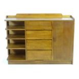 An early 20thC oak Bowman Bros side cabinet, a modernist style cabinet with a shaped upstand above