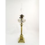 A late 19thC / early 20thC brass oil lamp with cut glass reservoir. The whole standing approx. 35"