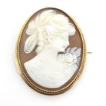 A 20thC shell carved cameo brooch in a 9ct gold mount. 1 1/2" high Please Note - we do not make