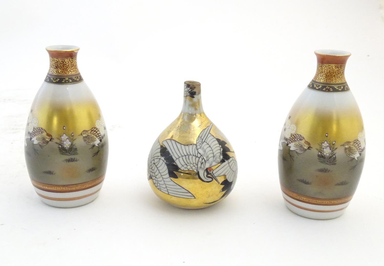 Three Japanese vases, comprising a pair decorated with a landscape scene with quail birds and