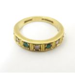 An 18ct gold ring set with 4 emeralds and 3 diamonds. Ring size approx K Please Note - we do not