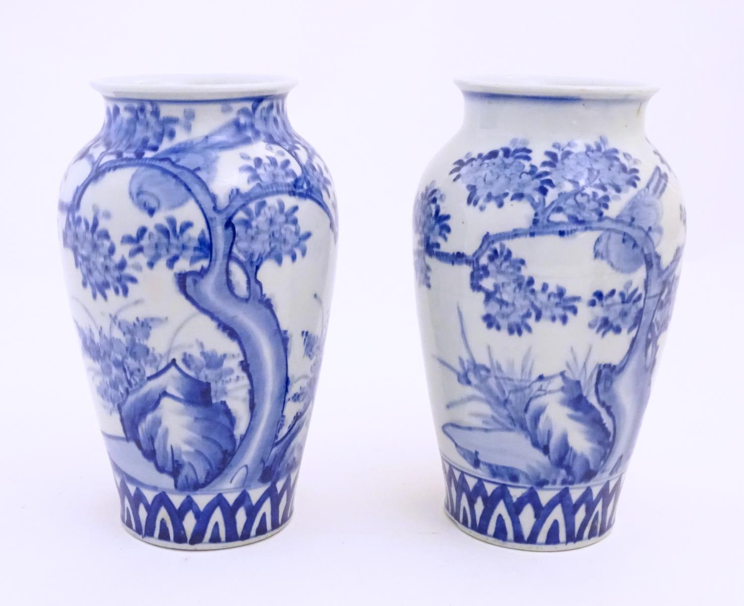 Two Chinese blue and white vases decorated with landscape scene with birds and trees. Approx. 9 3/4"