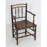 An early 19thC spindle back open armchair, with bowed top rails, swept arms and turned uprights
