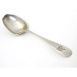 A silver teaspoon with engraved decoration to handle depicting a figure playing bowls. Hallmarked