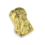 An Art Nouveau brass plaque with embossed decoration depicting a lady with flowing drapery.