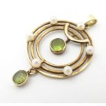 A 9ct gold pendant of circular form set with peridot and seed pearl approx. 1 1/2" long Please