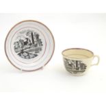 A 19thC tea cup and saucer with monochrome transfer decoration depicting a river landscape with a