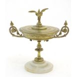 A 20thC brass lidded tazza with scrolling foliate decoration and a bird finial. Mounted on a