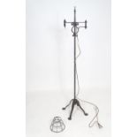 An Arts & Crafts wrought iron standard lamp, the top section adjustable for height and with