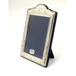 A silver mounted photograph frame with ribbon and swag decoration, hallmarked Sheffield 1994,