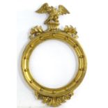 A 19thC carved gilt wood frame of round form surmounted by an eagle. Approx. 16" diameter Please