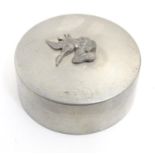 An early 20thC pewter pot and cover of circular form with applied gun dog and bird detail to lid.