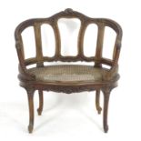 An early 20thC French Louis VI style chair with a carved and moulded frame above a caned seat,