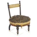 A late 19thC ebonised nursing chair with turned supports above a rounded seat and raised on fluted