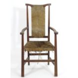 A late 19thC oak Arts & Crafts open armchair attributed to George Walton, having a shaped top rail