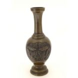 An Oriental bronze vase of baluster form with a stepped base and neck, the body with cast