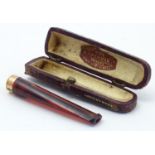 A Victorian amber cheroot mouthpiece / holder with case. The mount marked '9ct' 'Gold' and 'W.H.