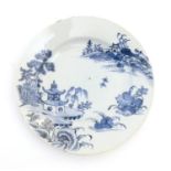 A Chinese blue and white plate with a landscape scene with pagodas, flowers, etc. Approx. 9"