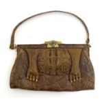 An early 20thC vintage ladies crocodile skin handbag with feet decoration and dark brown suede